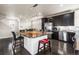 Contemporary kitchen with stainless steel appliances, dark cabinetry, granite countertops, and a large center island at 18651 E 53Rd Ave, Denver, CO 80249