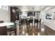 Contemporary kitchen with stainless steel appliances, dark cabinetry, granite countertops, and an island with seating at 18651 E 53Rd Ave, Denver, CO 80249