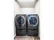 Modern laundry room featuring front-load washer and dryer on pedestal bases for easy access at 18651 E 53Rd Ave, Denver, CO 80249