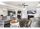 Open living room with hardwood flooring features kitchen, ceiling fan, and a large screen television at 18651 E 53Rd Ave, Denver, CO 80249