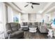 Bright living room boasts large windows, hardwood floors, and comfortable gray sectional sofa at 18651 E 53Rd Ave, Denver, CO 80249