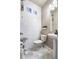Stylish powder room featuring textured white tile, modern fixtures, and unique decorative accents at 18651 E 53Rd Ave, Denver, CO 80249
