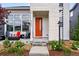 Welcoming porch with modern seating and a vibrant orange door, enhancing the home's curb appeal at 6237 Stable View St, Castle Pines, CO 80108