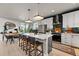 Modern kitchen featuring an island with bar stools, stainless steel appliances, and stylish backsplash at 6237 Stable View St, Castle Pines, CO 80108