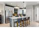 Bright kitchen features white cabinets, stainless steel appliances, and a spacious island with bar seating at 6237 Stable View St, Castle Pines, CO 80108
