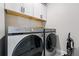 Laundry room showcasing modern silver Samsung washer and dryer set with white cabinets above at 6237 Stable View St, Castle Pines, CO 80108