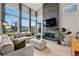 This spacious living room features high ceilings, large windows, and a cozy fireplace at 6237 Stable View St, Castle Pines, CO 80108