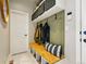 Well-organized mud room with bench seating, hooks, storage, and white panel door at 6237 Stable View St, Castle Pines, CO 80108
