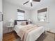 Bedroom features hardwood floors, two windows, ceiling fan and a bed with stylish throw pillows at 660 S Clarkson St, Denver, CO 80209