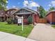 Charming brick home featuring a well-manicured lawn, garden beds, and a 'For Sale' sign at 660 S Clarkson St, Denver, CO 80209