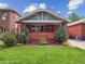 Charming brick home featuring a well-manicured lawn, garden beds, and covered porch at 660 S Clarkson St, Denver, CO 80209