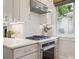 Close-up of kitchen features stainless appliances, white cabinets and pretty tiled backsplash at 660 S Clarkson St, Denver, CO 80209