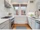 Kitchen with stainless steel appliances, stylish sink, white cabinets, and plenty of natural light at 660 S Clarkson St, Denver, CO 80209