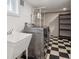 Modern laundry room with checkerboard floors, sink, shelving and new washer/dryer at 660 S Clarkson St, Denver, CO 80209