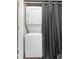 A stacked washer and dryer unit is conveniently tucked away behind a curtain at 16001 E Alaska Pl # 12, Aurora, CO 80017