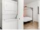 Bedroom with front-loading washer and dryer with an elegant wood floor and modern canopy style bed at 2958 Syracuse St # 412, Denver, CO 80238