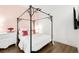 Bedroom with wood floors, decorated with a canopy bed, pink accent wall, and elegant dresser at 2958 Syracuse St # 412, Denver, CO 80238