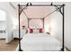 Well-lit bedroom with eye-catching canopy bed, white walls and light pink accent wall at 2958 Syracuse St # 412, Denver, CO 80238