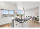 Open-concept kitchen with island, stainless steel dishwasher, and a view into the living room at 2958 Syracuse St # 412, Denver, CO 80238