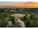 Stunning aerial view of a well-manicured home surrounded by lush greenery and a beautiful sunset in the background at 422 Suffolk Ln, Castle Rock, CO 80108