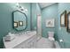 Stylish bathroom with teal walls, framed mirrors, a white vanity, and glass enclosed shower at 422 Suffolk Ln, Castle Rock, CO 80108