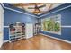Blue bedroom featuring wood trim and ceiling beams, hardwood floors, and built in bookshelves at 422 Suffolk Ln, Castle Rock, CO 80108