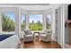 Bright bedroom with large windows framing lush greenery, features hardwood floors and neutral armchairs at 422 Suffolk Ln, Castle Rock, CO 80108