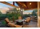 An inviting covered deck with a fire pit, outdoor seating, and stunning sunset views, perfect for relaxation and entertaining at 422 Suffolk Ln, Castle Rock, CO 80108
