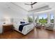 Bright main bedroom featuring a tray ceiling, large windows with green views, and hardwood floors at 422 Suffolk Ln, Castle Rock, CO 80108