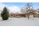 Ranch-style home with snow-covered front yard, attached garage, and mature trees at 8111 S Marion Ct, Centennial, CO 80122