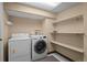 Basement laundry room with washer, dryer and shelving at 8111 S Marion Ct, Centennial, CO 80122