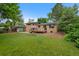 Backyard view showcasing brick house, deck, garden, and lush lawn at 9025 W 4Th Ave, Lakewood, CO 80226