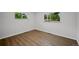 Sunlit bedroom featuring hardwood floors, white walls, and dual windows at 9025 W 4Th Ave, Lakewood, CO 80226