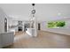 Open-concept kitchen features white cabinetry, an island, stainless appliances, and a light-filled dining area at 9025 W 4Th Ave, Lakewood, CO 80226