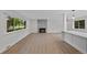 Bright living room featuring hardwood floors, a tiled fireplace, and views of the trees outside at 9025 W 4Th Ave, Lakewood, CO 80226
