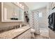 Bright bathroom features granite countertops, mirrored vanity, and tiled shower and tub at 2208 Emery St, Longmont, CO 80501