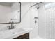 Modern bathroom featuring white subway tile in a herringbone pattern and a new vanity with contemporary fixtures at 7891 Maria St, Westminster, CO 80030