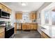 Well-lit kitchen featuring updated appliances, wood cabinetry, granite countertops, and neutral backsplash at 7891 Maria St, Westminster, CO 80030