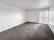 An empty bedroom with plush carpeting, large window, and white walls at 480 S Marion Pkwy # 1202, Denver, CO 80209
