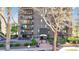 Entrance to high rise condo building with well-manicured landscaping and seating at 480 S Marion Pkwy # 1202, Denver, CO 80209