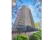 Exterior shot of condo building with patios, blue skies, and purple blossoming tree in spring at 480 S Marion Pkwy # 1202, Denver, CO 80209