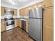 Modern kitchen with stainless steel appliances, wood floors, and light wood cabinets at 480 S Marion Pkwy # 1202, Denver, CO 80209