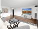 Bright living room showcasing hardwood floors and entertainment center with large-screen TV at 480 S Marion Pkwy # 1202, Denver, CO 80209