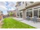 A well-manicured backyard with a patio, green lawn, and two outdoor chairs at 18112 E 104Th Way, Commerce City, CO 80022