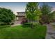 Well-manicured backyard featuring lush green grass, landscaping and mature trees in a private setting at 18112 E 104Th Way, Commerce City, CO 80022