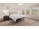 A bright bedroom with three windows, neutral carpet, and contemporary lamps on the bedside tables at 18112 E 104Th Way, Commerce City, CO 80022