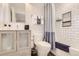 Well-lit bathroom featuring tiled walls, sleek vanity, modern fixtures, and a shower with stylish curtain at 4441 N Meade St, Denver, CO 80211