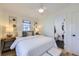 Bright bedroom featuring white walls, ceiling fan, ensuite bathroom, and stylish bedside decor at 4441 N Meade St, Denver, CO 80211