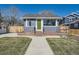 Charming home with well-manicured lawn, green door, brick foundation, and a large picture window at 4441 N Meade St, Denver, CO 80211