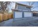 Exterior shot showcasing a two-car garage with white doors, wooden fence, and basketball hoop at 4441 N Meade St, Denver, CO 80211